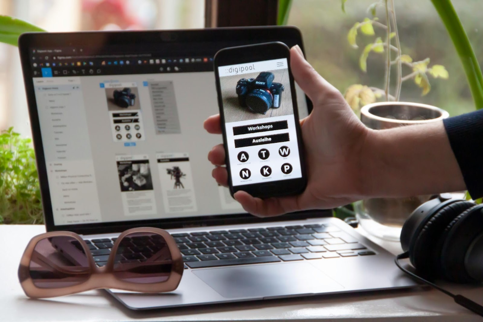 A strategist testing a responsive website design on a smartphone while managing the project on a laptop, demonstrating technical skills.