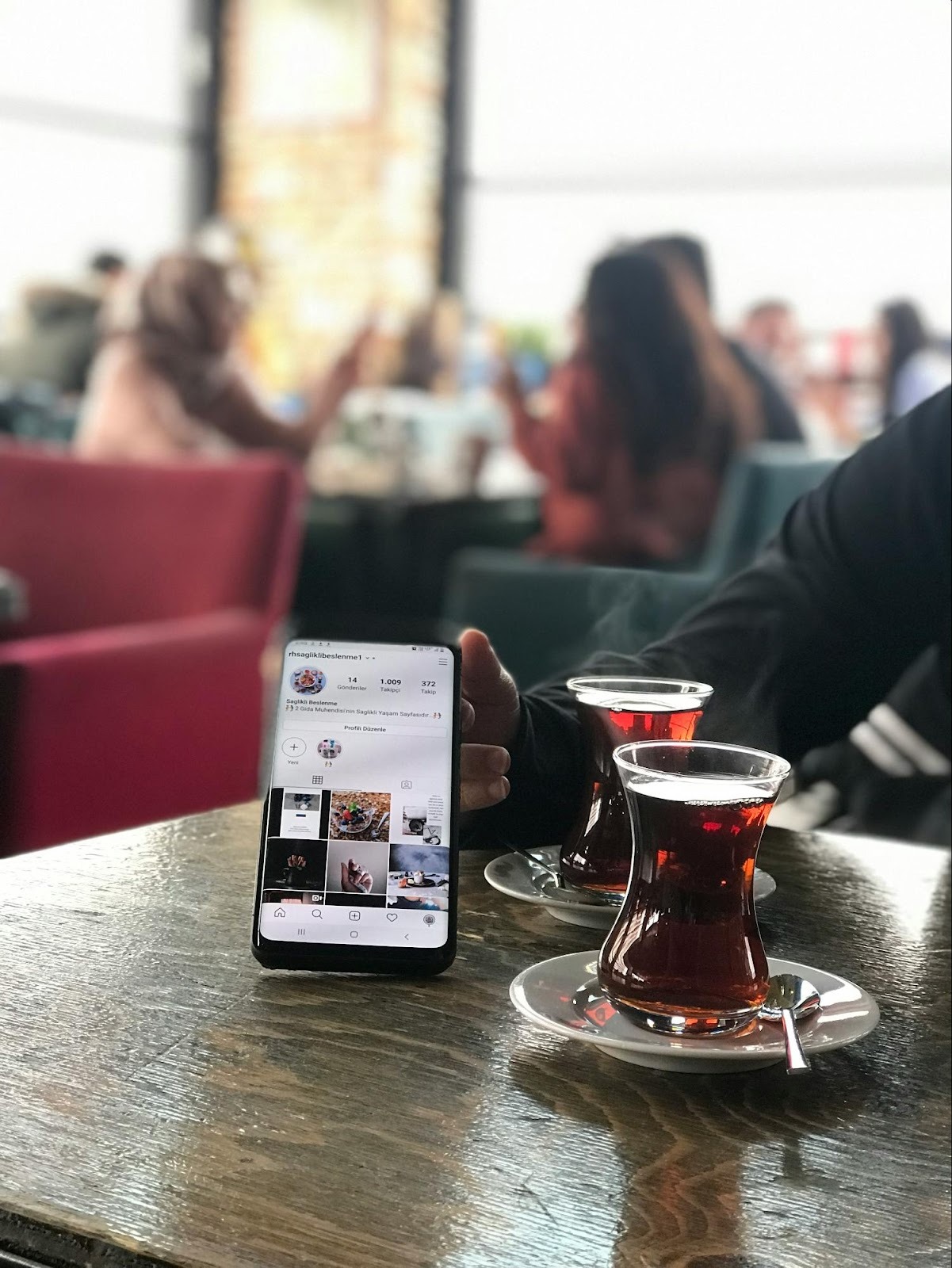 Smartphone on a café table displaying an Instagram profile, demonstrating how small businesses like coffee shops use social media to engage customers.