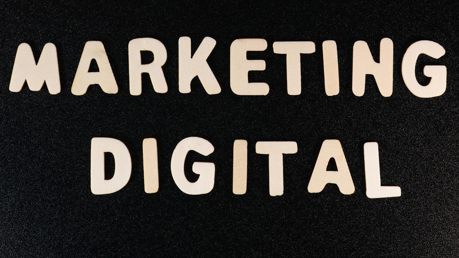 Wooden letters spelling Marketing Digital on a black background, highlighting the focus on digital services.