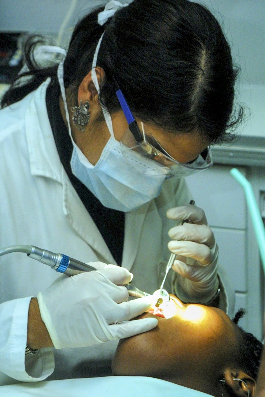 Dentist performing a procedure on a patient, demonstrating the clinical care and expertise highlighted in practice marketing.