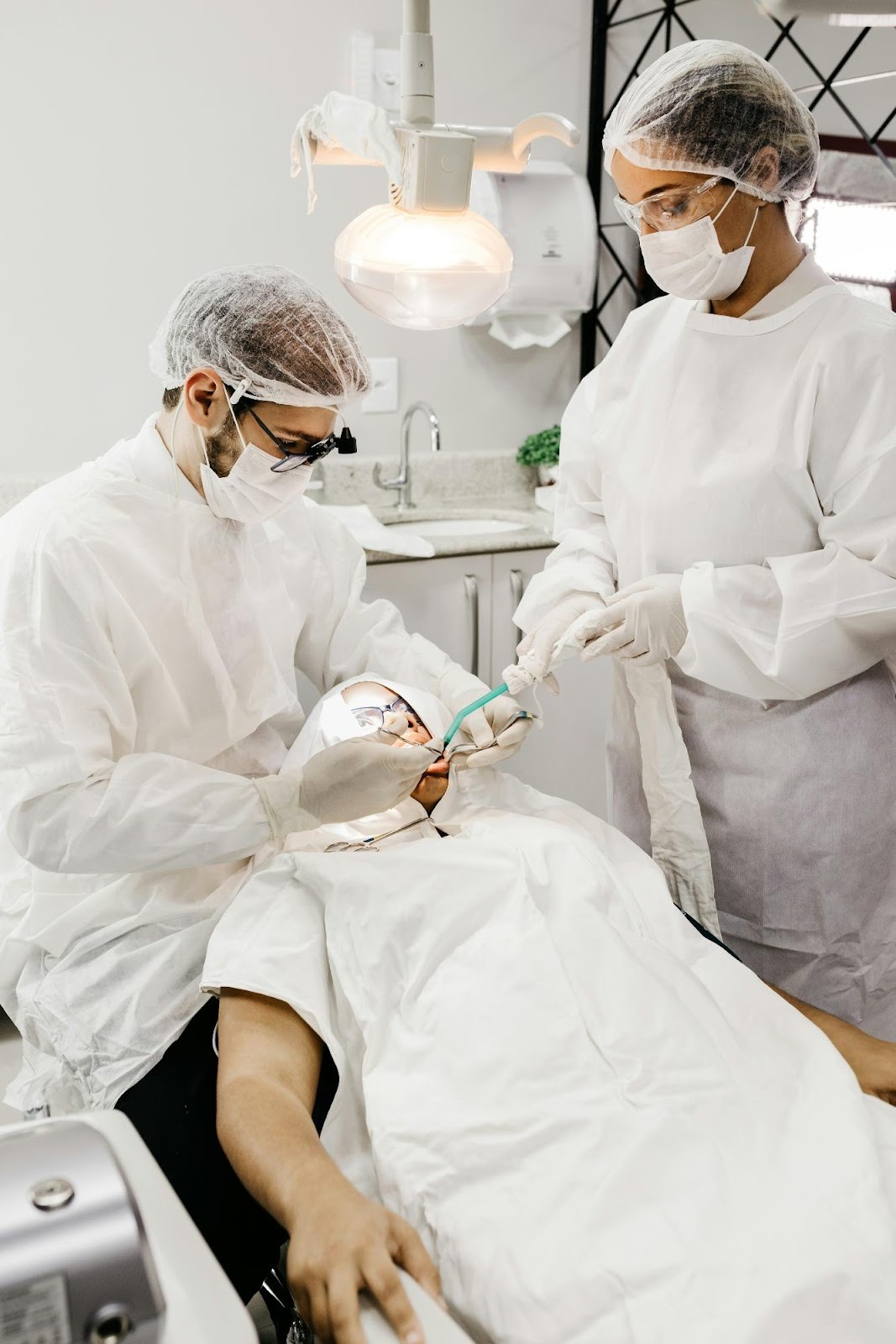 Dental team in full PPE treating a patient, showcasing safety protocols and professional care on a practice "About Us" page.