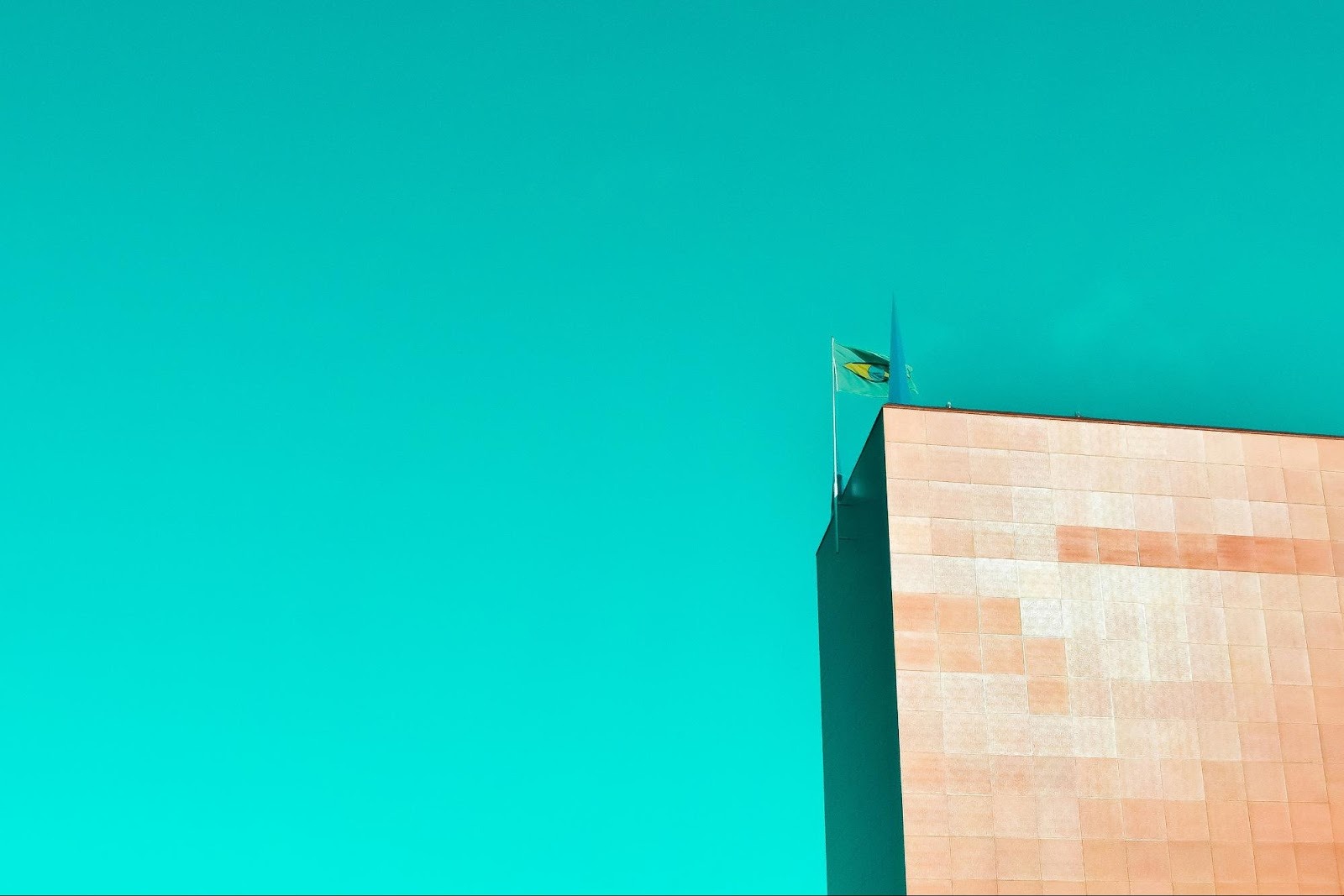 Minimalist building architecture against a teal sky, representing modern design aesthetics and brand perspective.