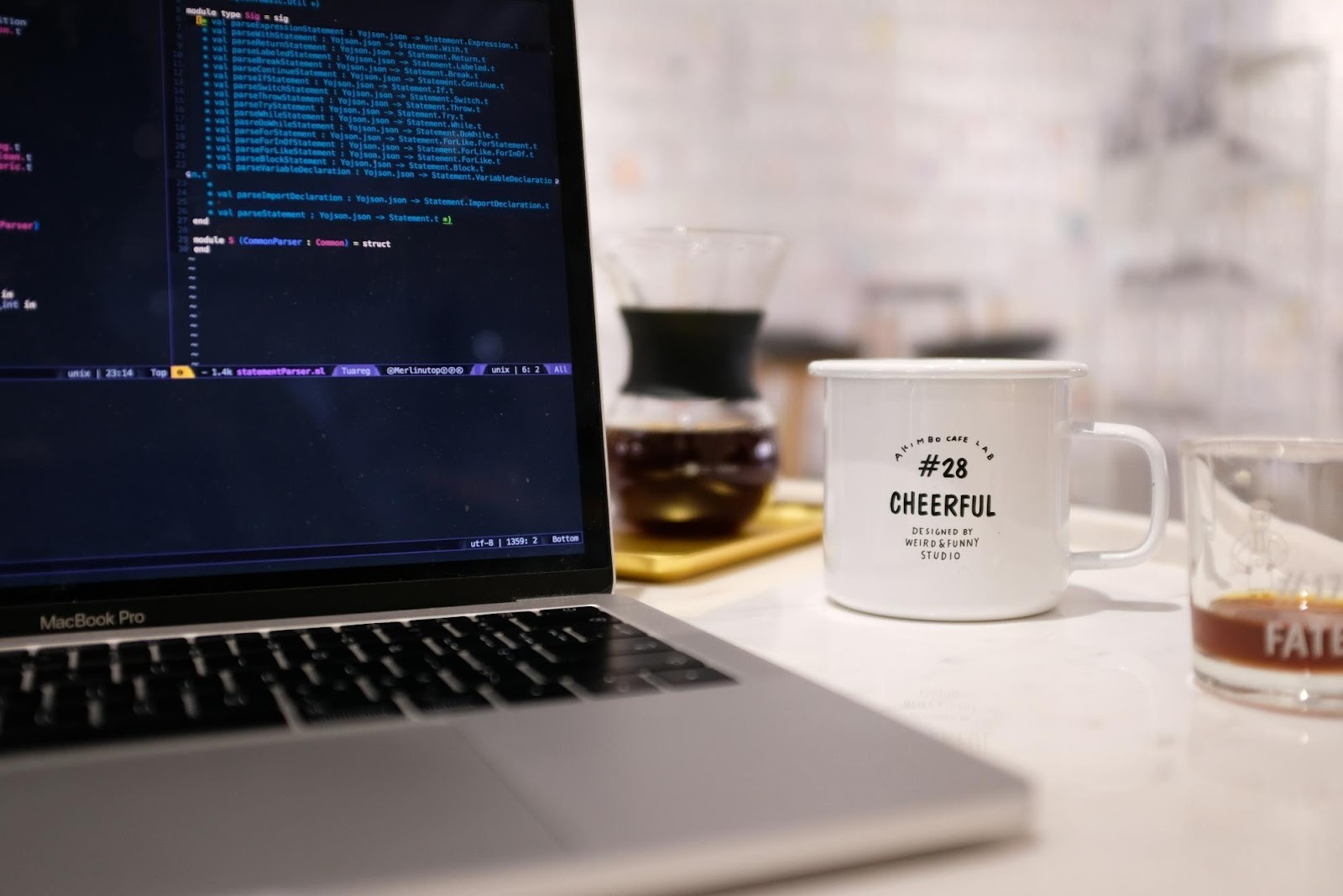 Laptop displaying code next to a coffee mug, illustrating the technical audit and development side of digital marketing.