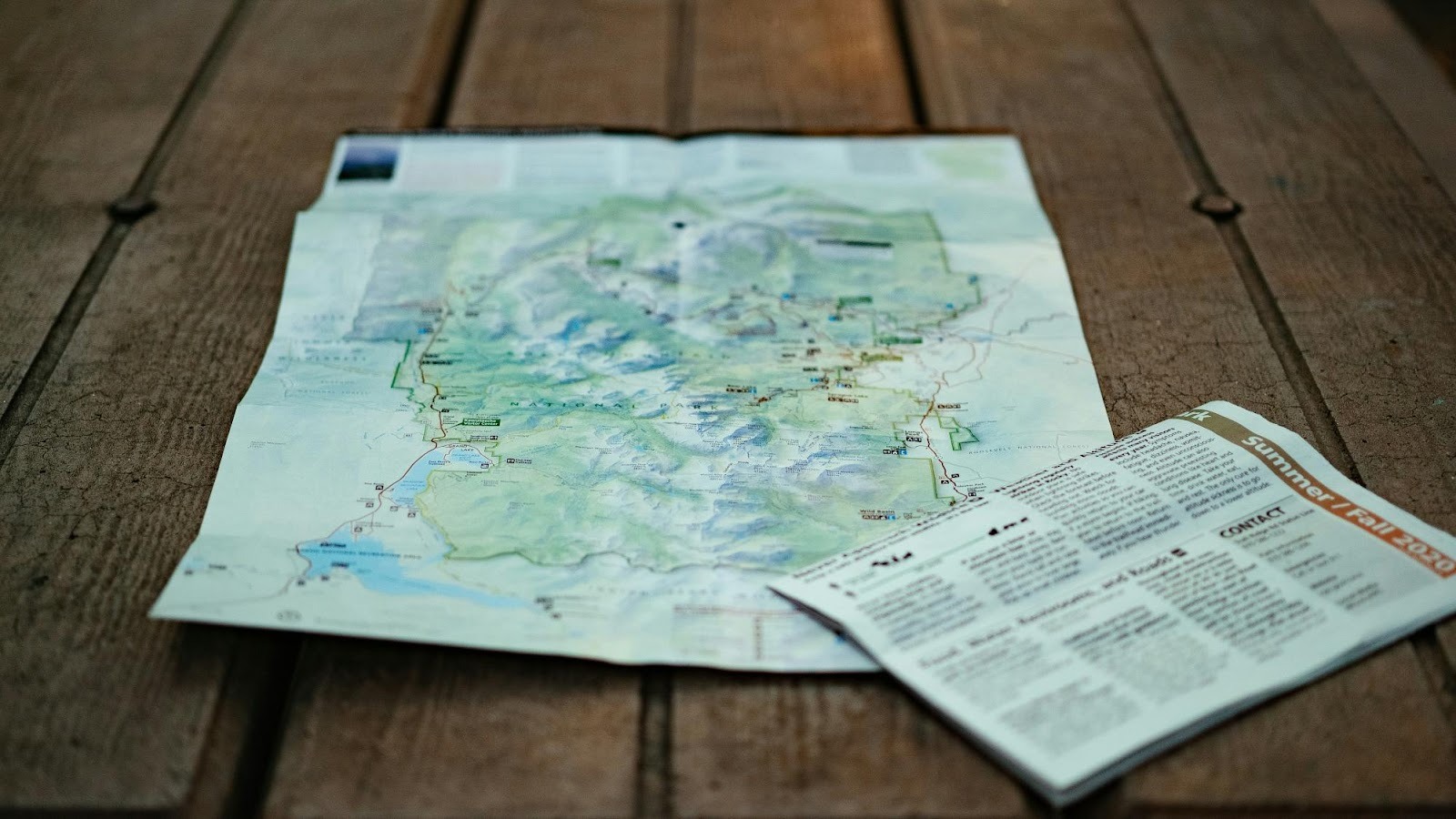 Folded paper map on a wooden table, representing the strategic roadmap and planning needed to navigate digital marketing goals.