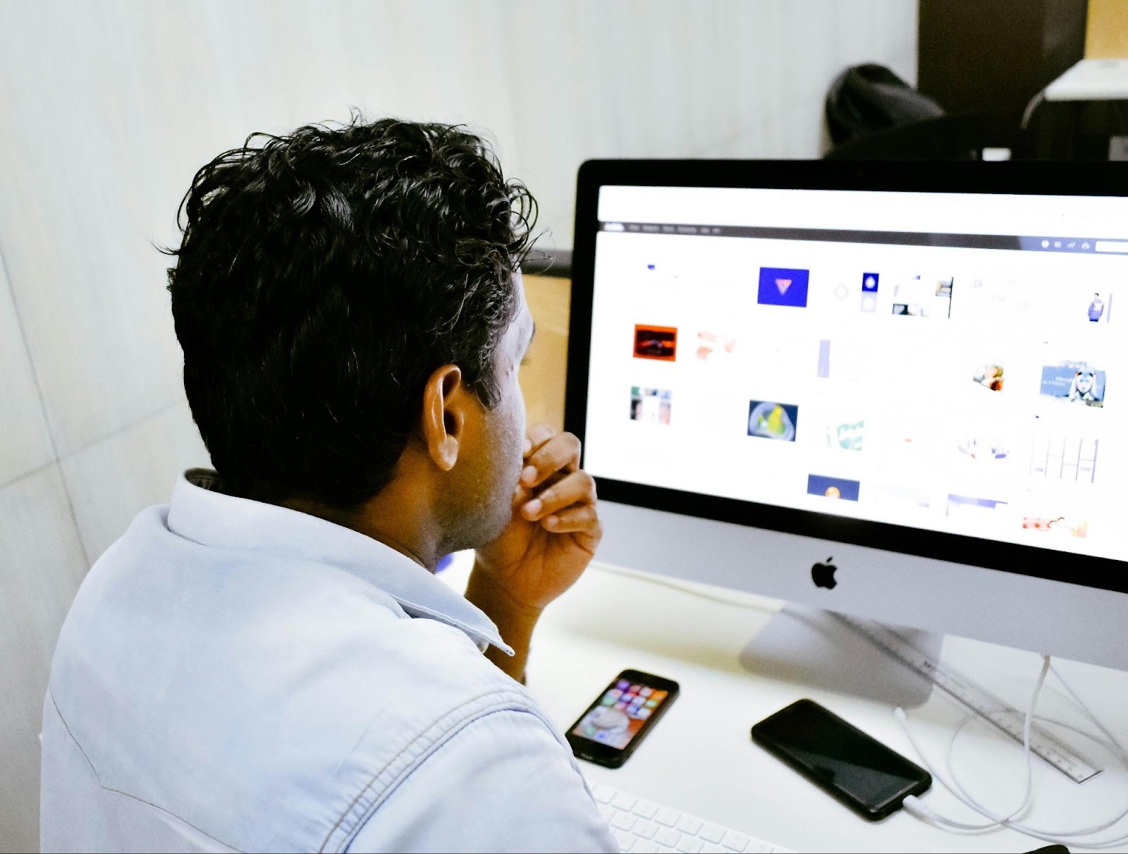 Digital marketer analyzing website layouts and user behavior on a desktop computer, critical for evaluating digital strategy performance.