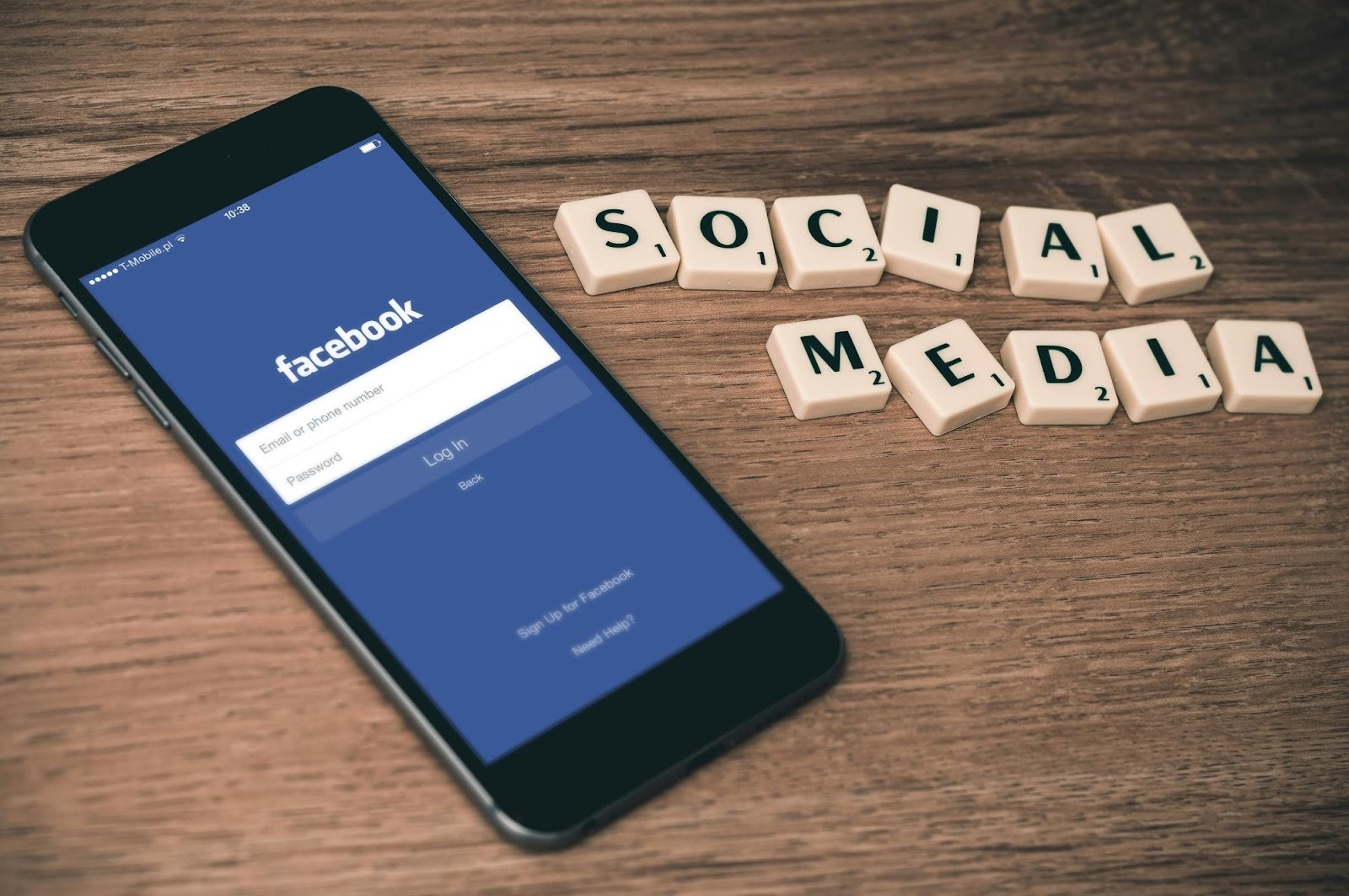 Smartphone displaying Facebook login screen next to "Social Media" tiles, illustrating social media marketing for plumbing companies.