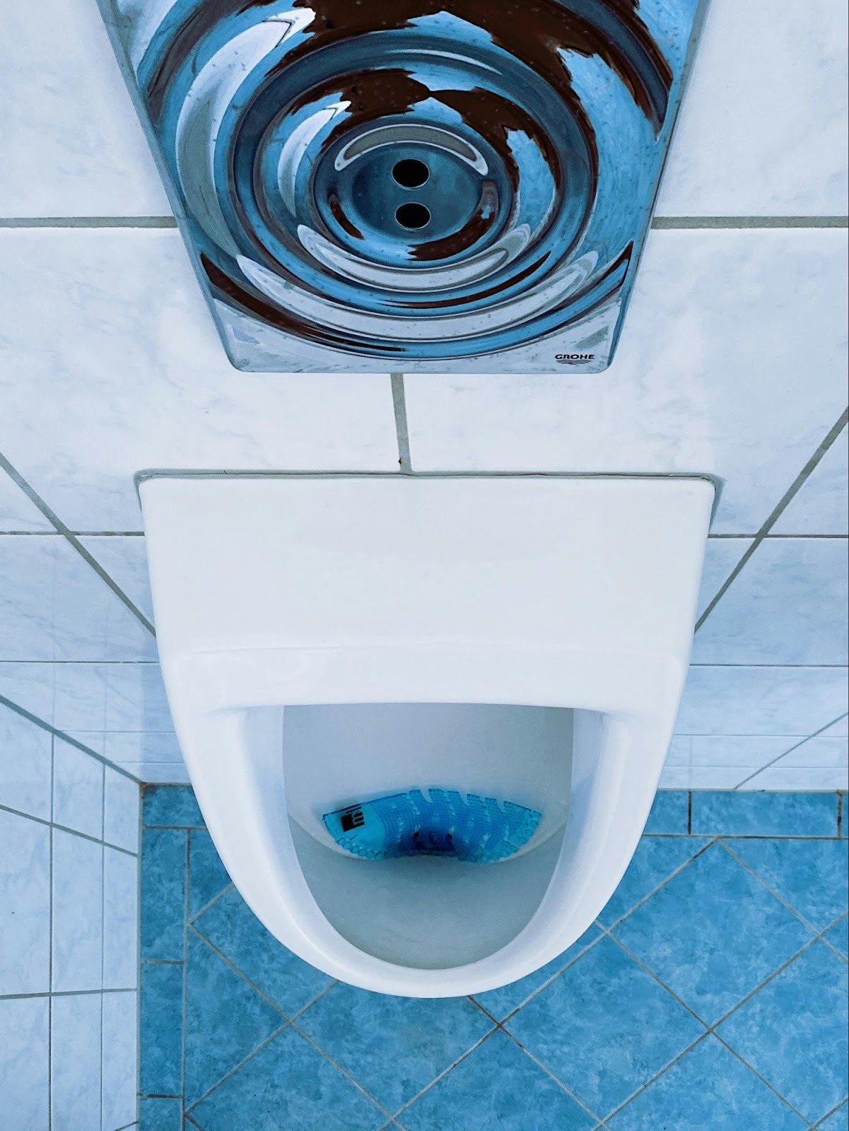 Top-down view of a commercial urinal, representing commercial plumbing services and facility maintenance.